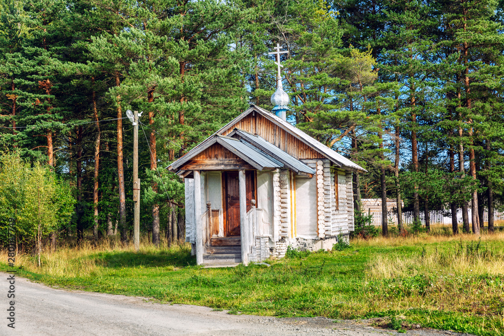 Old wooden church in a beautiful summer rustic landscape.