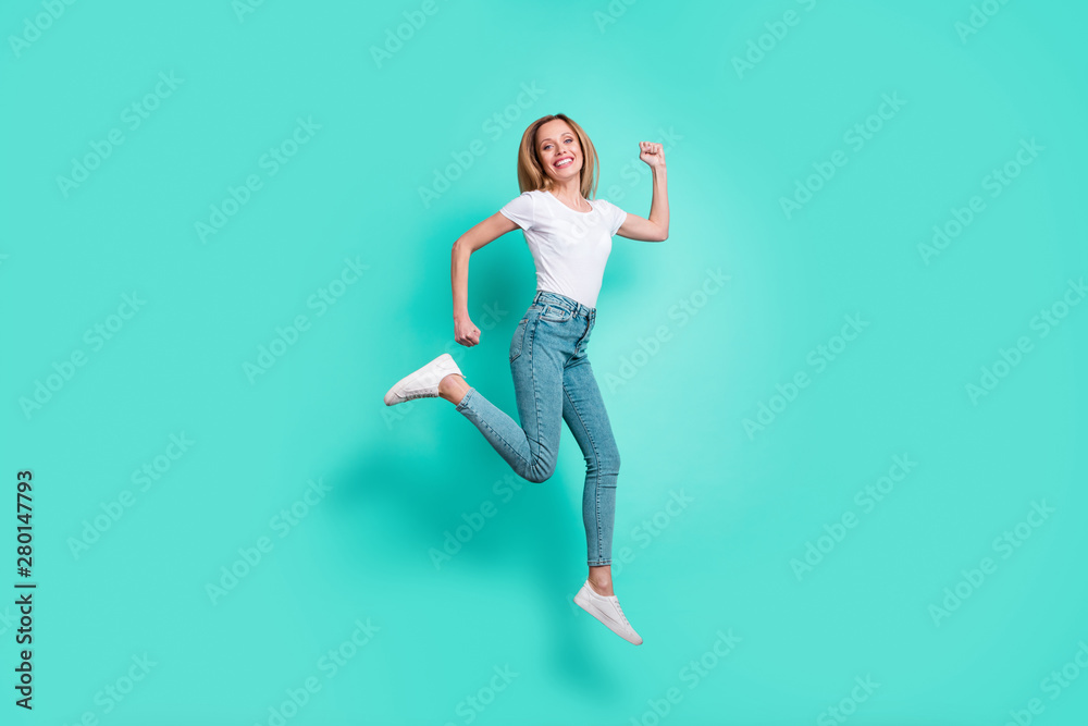 Full body photo of cute lady running with toothy smile isolated over teal turquoise background Full body photo of cute lady running with toothy smile isolated over teal turquoise background