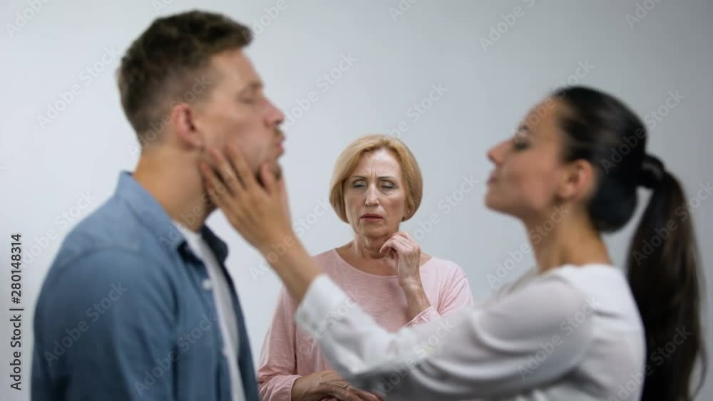 Worried mother looking at young couple in love, unwanted relationship, concept Worried mother looking at young couple in love, unwanted relationship, concept