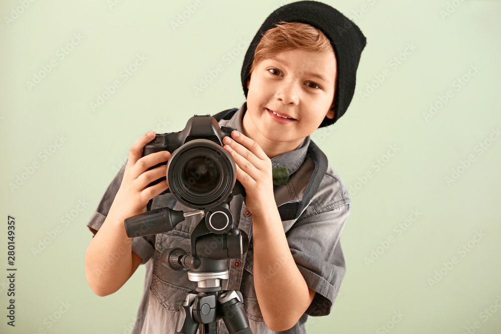 Cute little photographer with professional camera on color background Cute little photographer with professional camera on color background