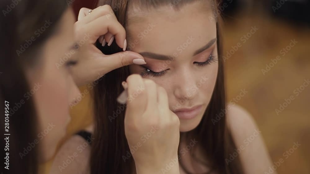 Model have a makeup by makeup artist in beauty salon. First person view. Redhead model with freckles. Close up of model's face with make up Model have a makeup by makeup artist in beauty salon. First person view. Redhead model with freckles. Close up of model's face with make up