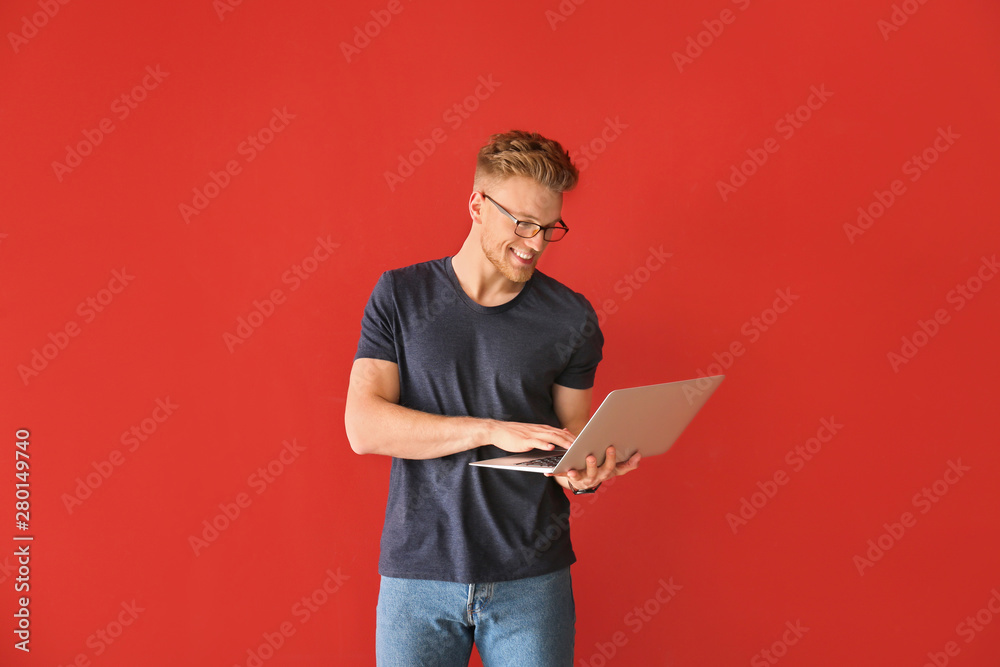 Handsome young man with laptop on color background Handsome young man with laptop on color background
