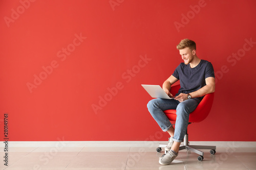 Handsome young man with lap...