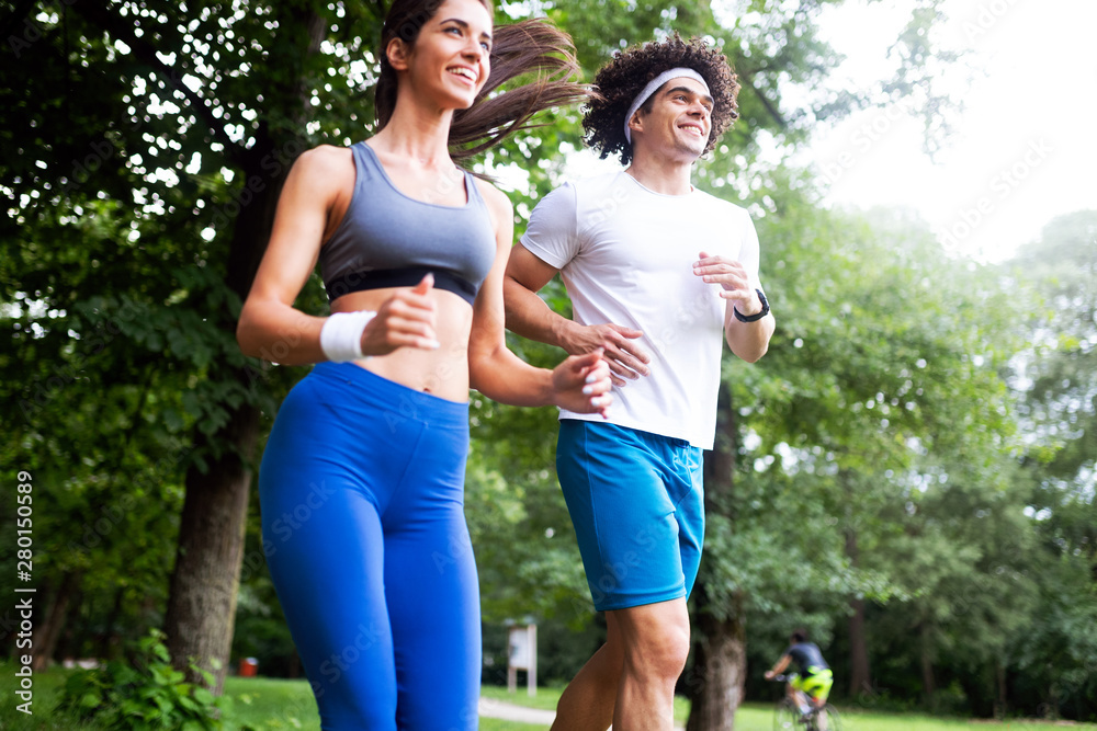 Obraz premium Happy young people jogging and exercising in nature
