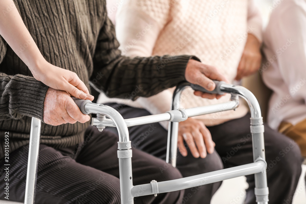 Obraz premium Young caregiver looking after senior people in nursing home