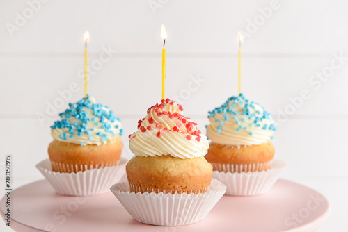 Stand with tasty Birthday cupcakes on white background