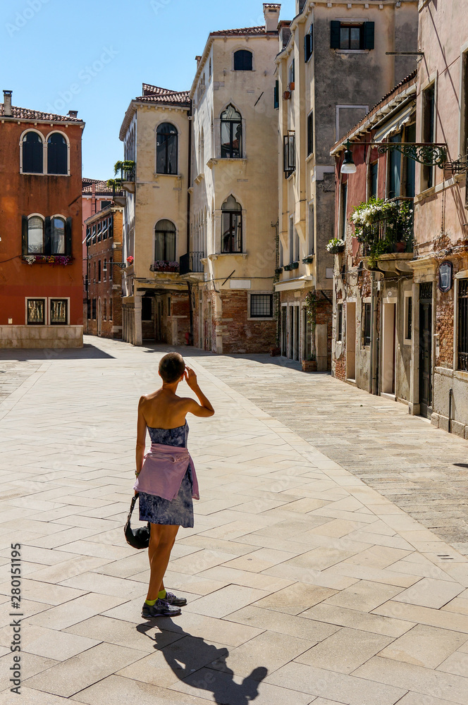 Picturesque town street with a tourist woman and view of european city