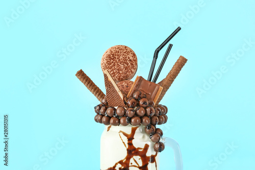 Mason jar with delicious freak shake on color background photo