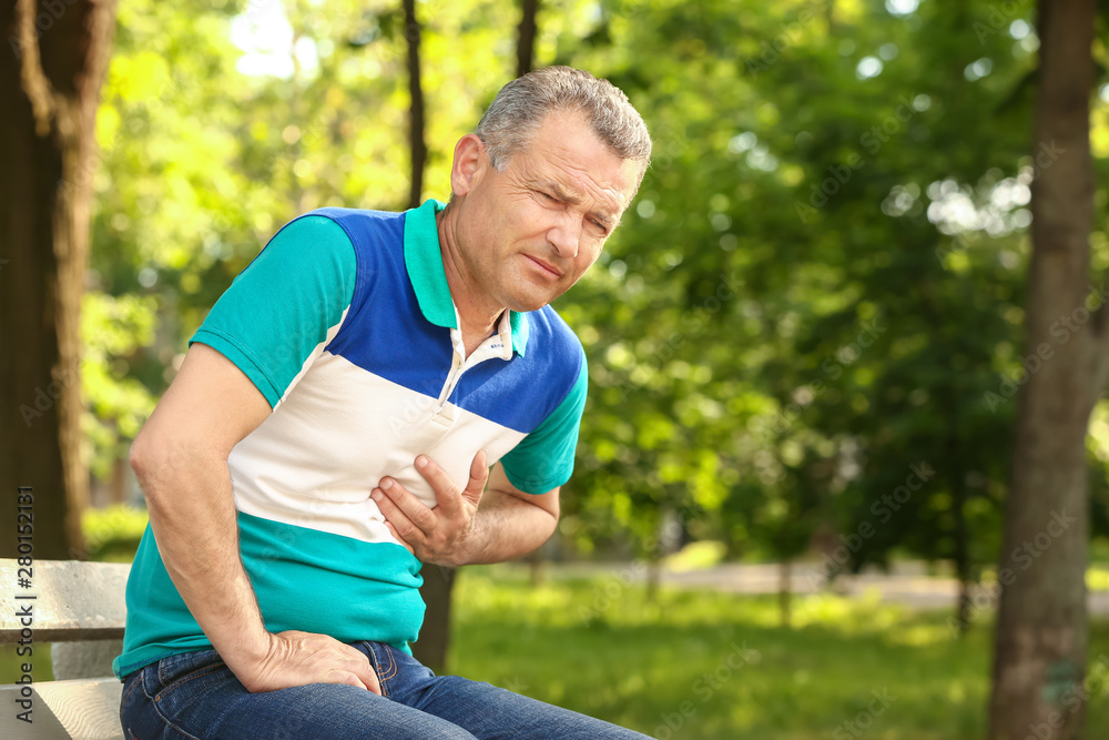 Fototapeta premium Mature man suffering from heart attack outdoors