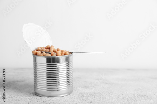 Tin can with beans on grey table photo