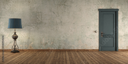 Grunge interior with blue door and floor lamp