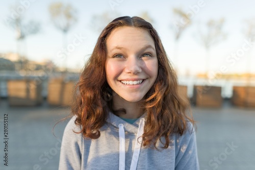 Outdoor portrait of beautiful smiling teenager girl 14, 15 years old photo