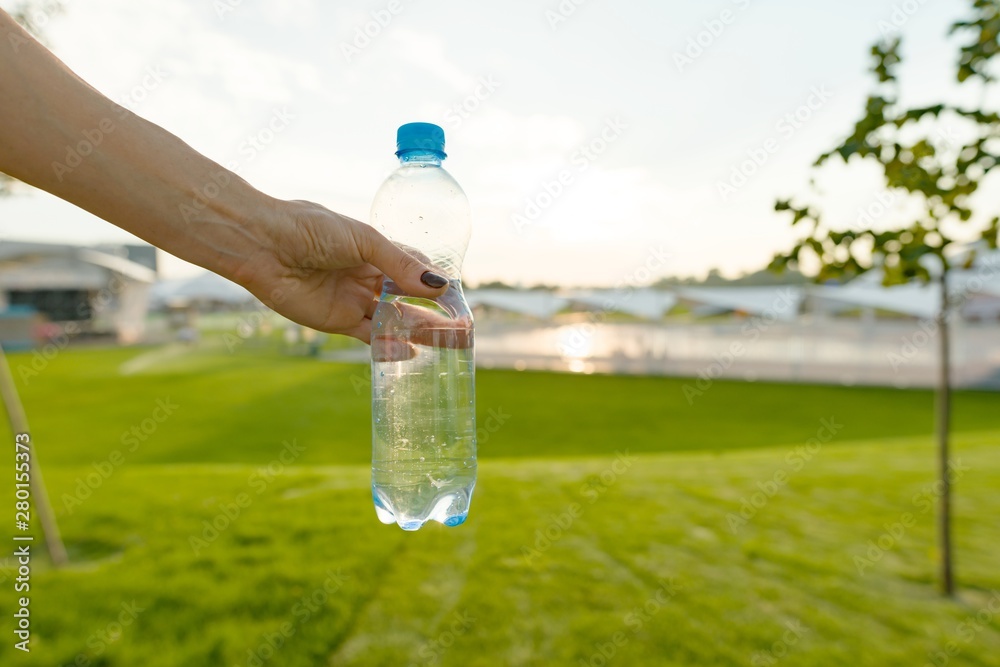 Bottle of water in female hand, copy space Bottle of water in female hand, copy space