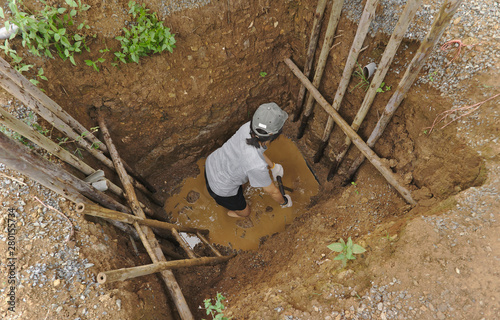 Woman worker drilling the hole in bamboo mine looking for raw gems stones and precious rocks in Thailand jewelry industry