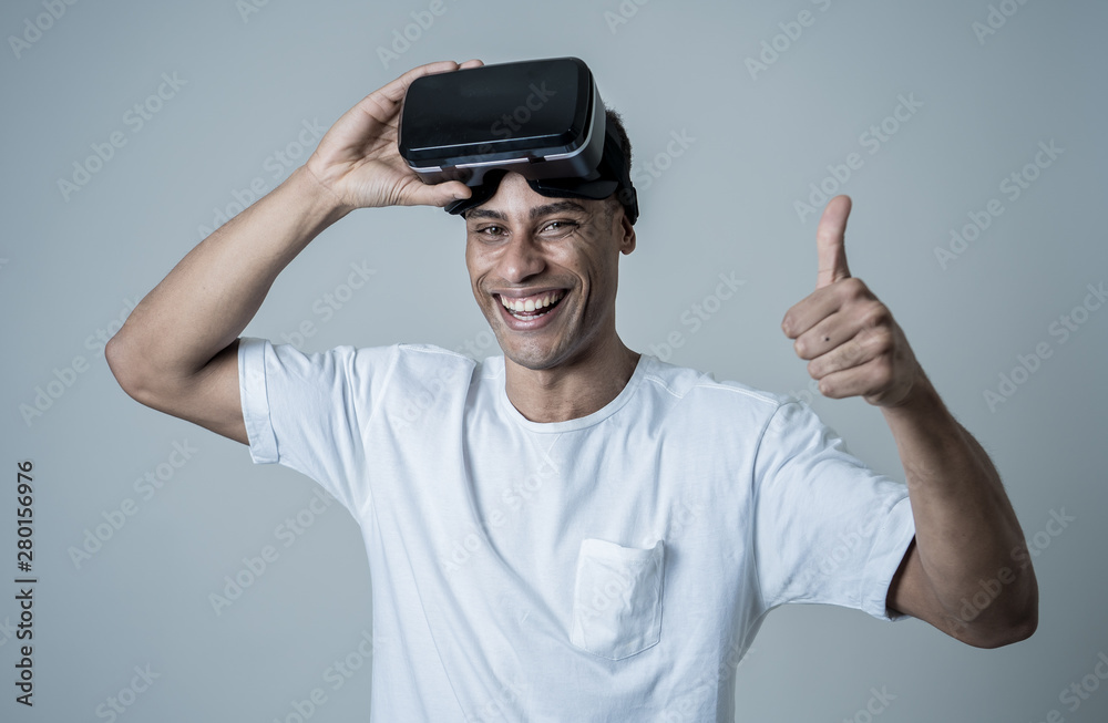 Portrait of cheerful young man wearing Virtual Reality goggles for first time smiling at camera Portrait of cheerful young man wearing Virtual Reality goggles for first time smiling at camera