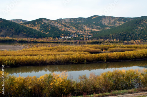 Between Ulan Ude and Ust-Barguzin Russia, autumn view of river with village in distance