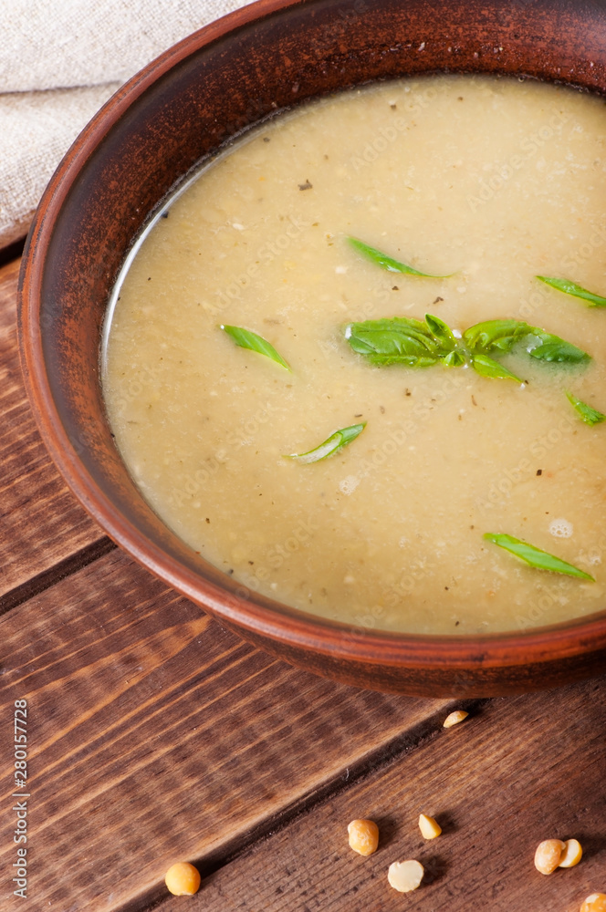 Pea soup in a clay plate on an old wooden background. Pea soup in a clay plate on an old wooden background.