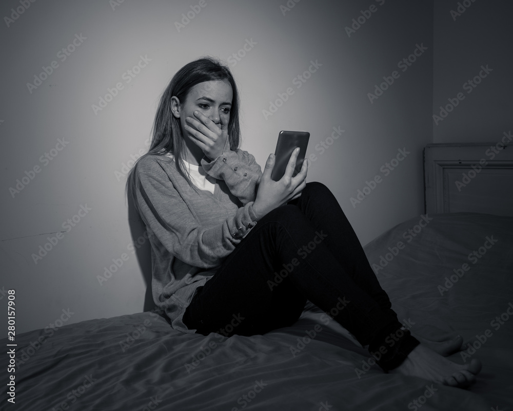 Depressed teenager girl on mobile phone victim of cyberbullying feeling sad, unhappy and lonely Depressed teenager girl on mobile phone victim of cyberbullying feeling sad, unhappy and lonely