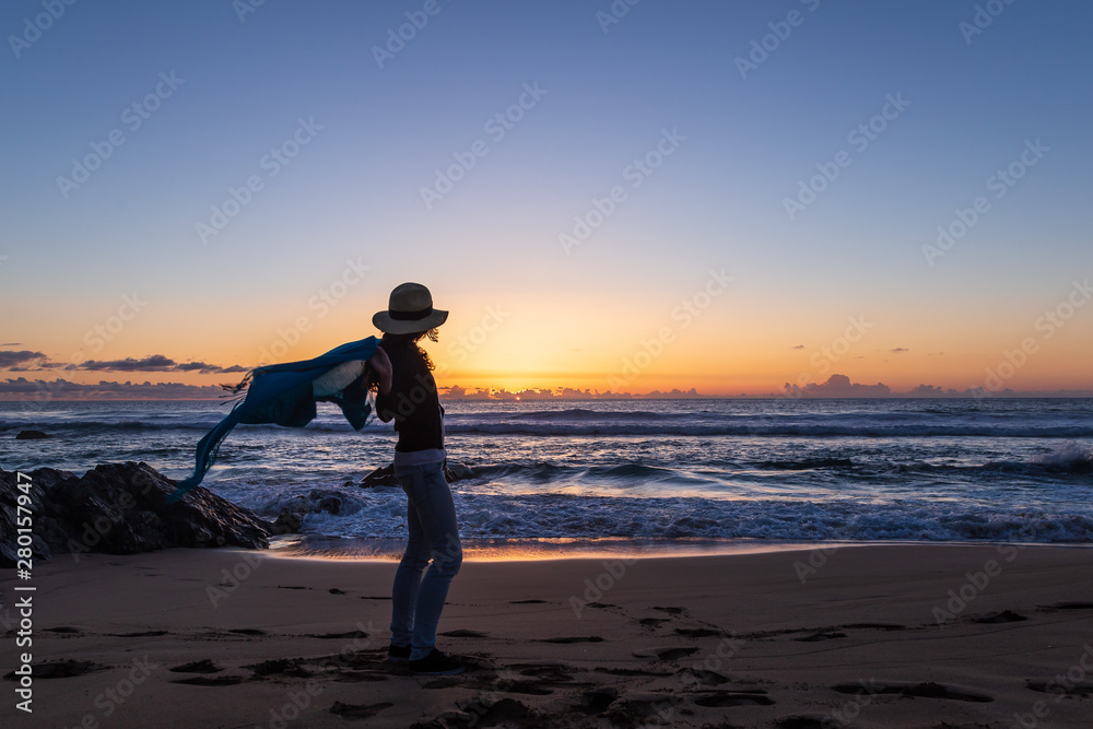Silhouette of young girl with hat, at sunset on Cotillo beach, Fuerteventura, Canary Islands, Spain.