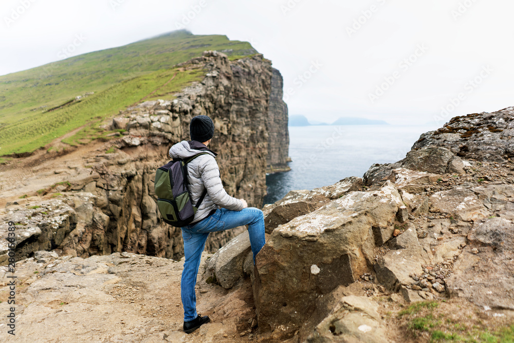 Young traveller enjoying hike on Soravgsvatn lake and the beauty of Faroese nature. Vagar, Faroe Islands.