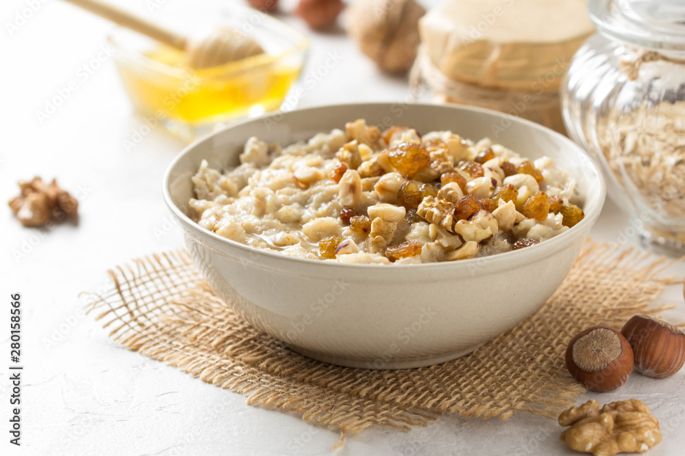 Oatmeal with nuts (hazelnuts, walnuts) and honey, porridge for Breakfast. Tasty, healthy food