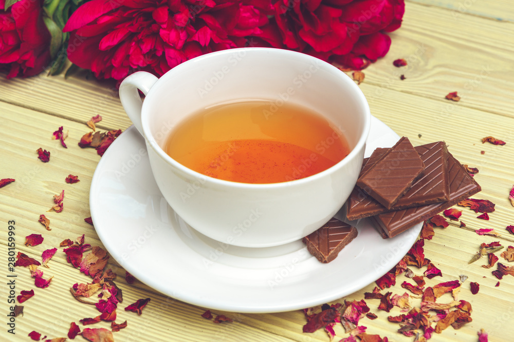Cup of green tea on table with fresh peony flowers Cup of green tea on table with fresh peony flowers