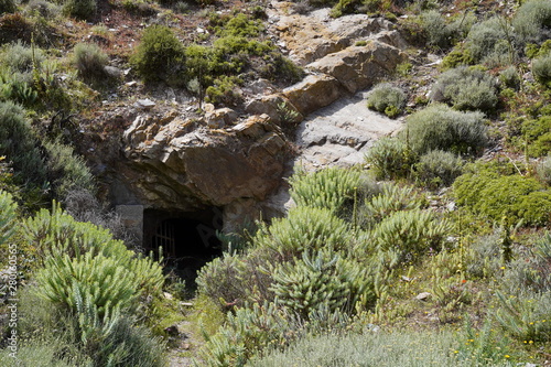 Lost places, Rusty grid barrier in front of a cave in Argientiera