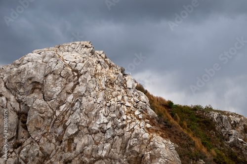 Lake Baikal Russia   rocky cliff top with storm clouds on Chivyrkuysky Bay