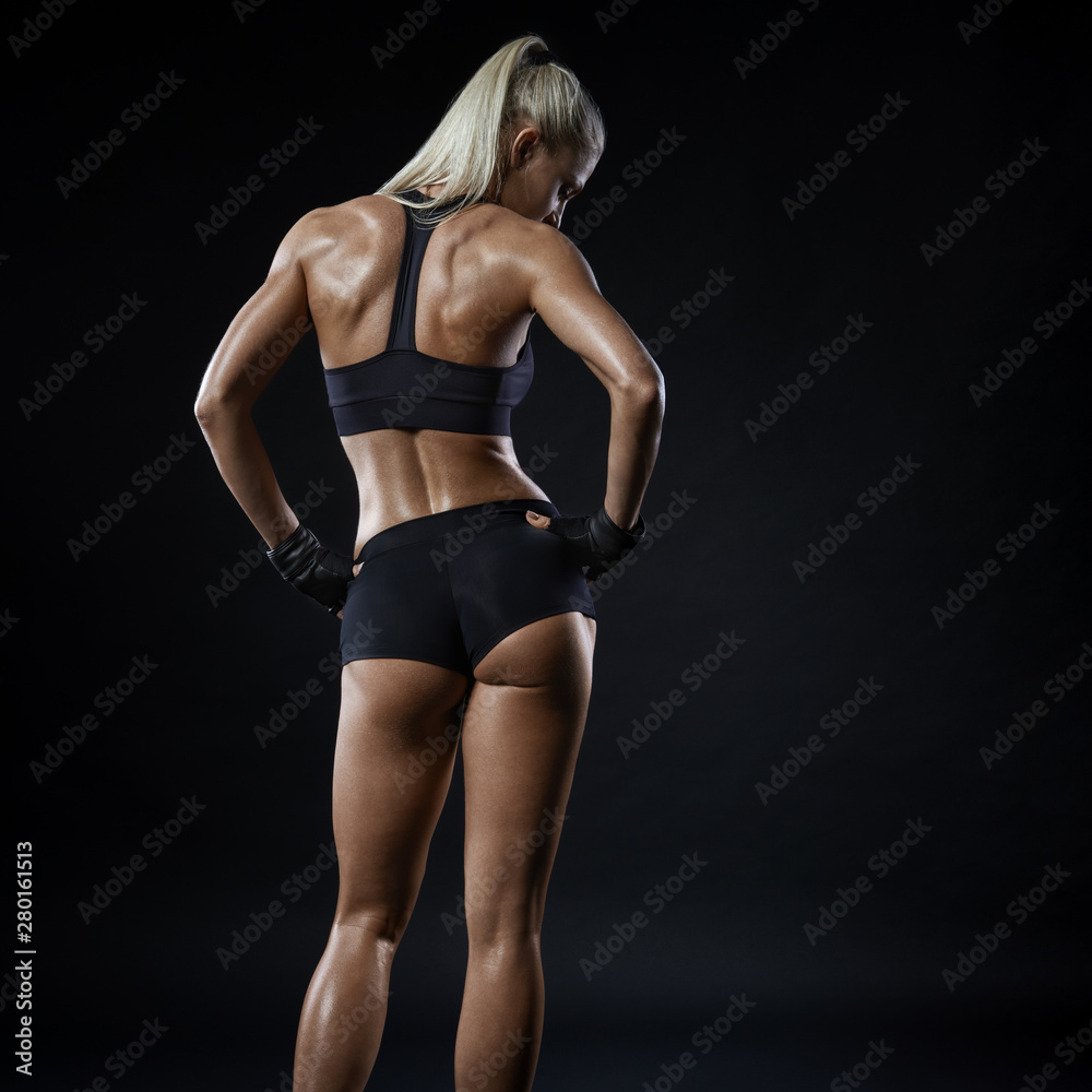 Young sports woman in sportswear stands back Young sports woman in sportswear stands back