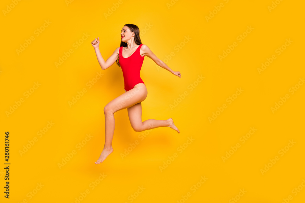 Full body profile photo of funny lady jumping high seaside sportive competitions champion speed jogging wear red swim suit isolated yellow background