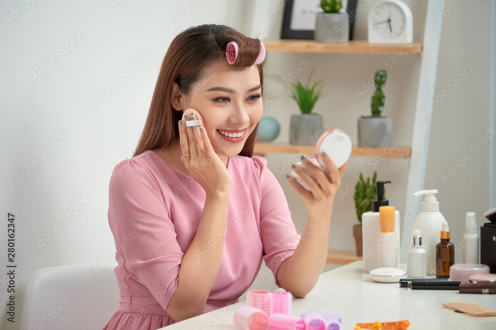 Close up portrait of charming pretty cute good-looking stylish trendy fashionable sexy applying powder with sponge on cheeks looking in mirror in morning Close up portrait of charming pretty cute good-looking stylish trendy fashionable sexy applying powder with sponge on cheeks looking in mirror in morning