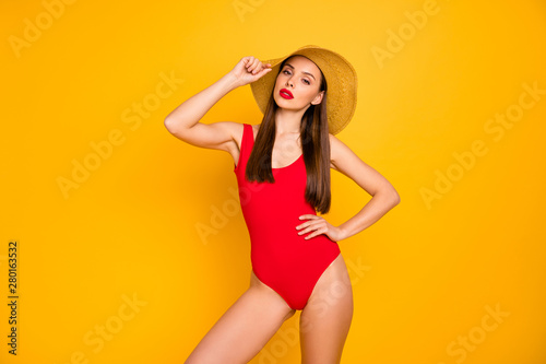 Portrait of her she nice-looking attractive glamorous lovely charming gorgeous adorable posh sporty straight-haired lady posing touching hat isolated over bright vivid shine yellow background