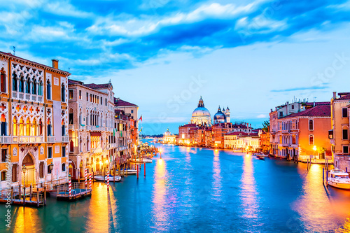 Basilica Santa Maria della Salute  Punta della Dogona and Grand Canal at blue hour sunset in Venice  Italy with boats and reflections.