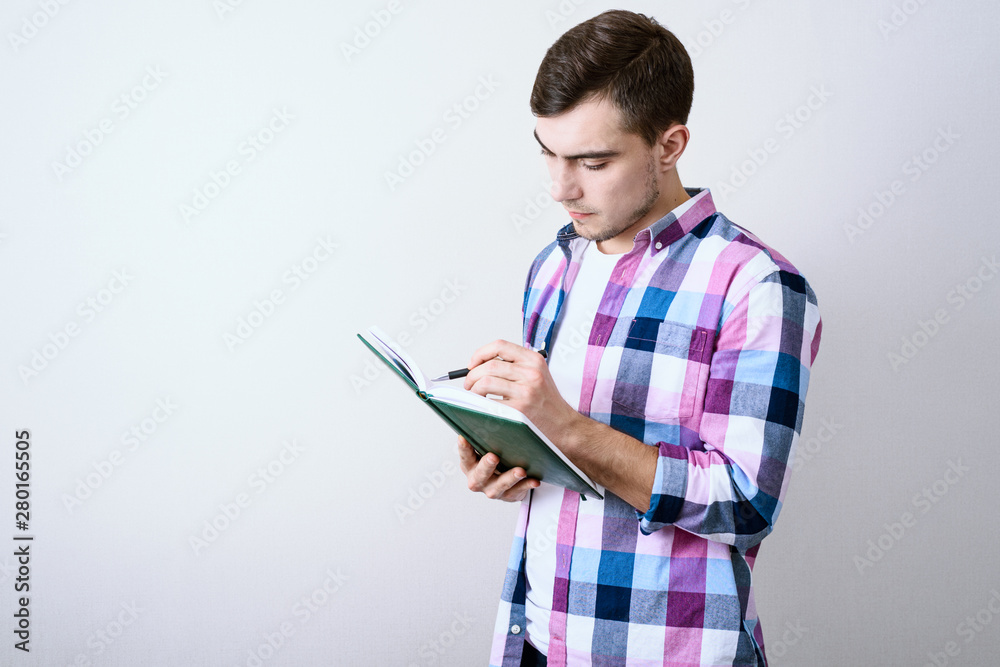 Young white male student studying lecture notes on gray background with copy space Young white male student studying lecture notes on gray background with copy space