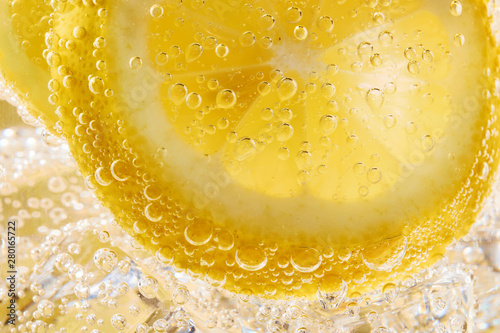 Close up of water with lemon slices and bubbles. Macro shot
