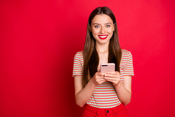 Photo of pretty charming funky lady in almost total red look holding checking-in her flight on smart phone isolated bright background