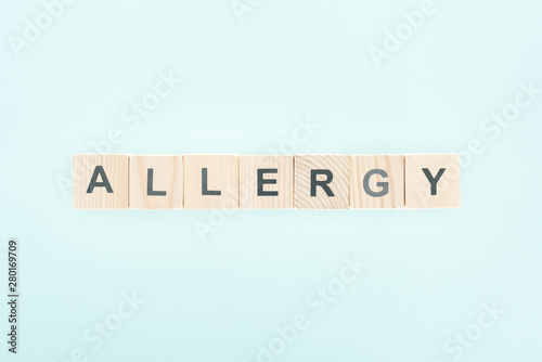 top view of wooden blocks with allergy lettering isolated on blue