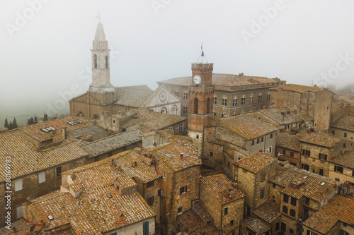 Aerial view of ancient italian town Pienza in Tuscany. Tile brown roofs, old town hall, narrow streets and church. photo
