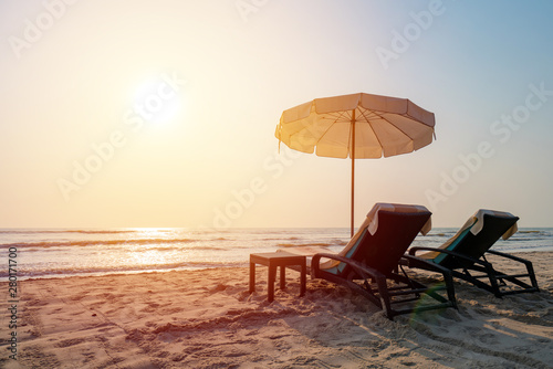 Sun umbrellas and chairs on tropical beach with sunset © CasanoWa Stutio