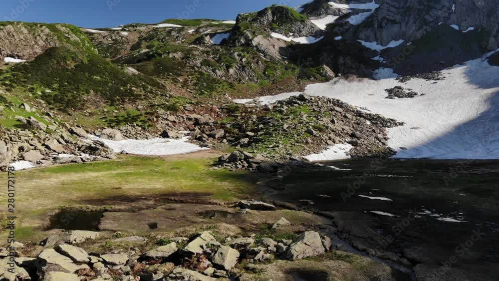 highland valley with grey stones and snow lying on ground highland valley with grey stones and snow lying on ground