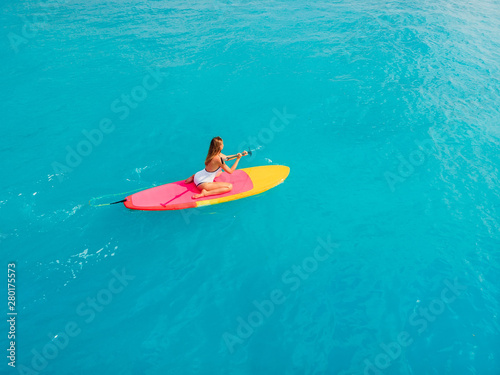 Stand up paddle boarding on a quiet blue sea.