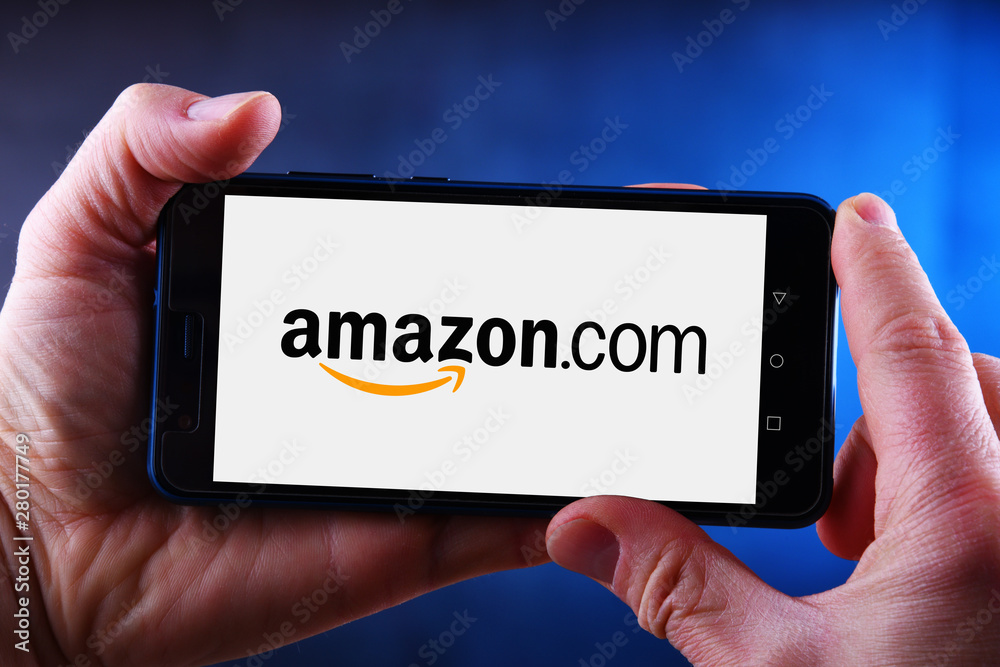 Hands holding smartphone displaying logo of Amazon Stock Photo | Adobe Stock