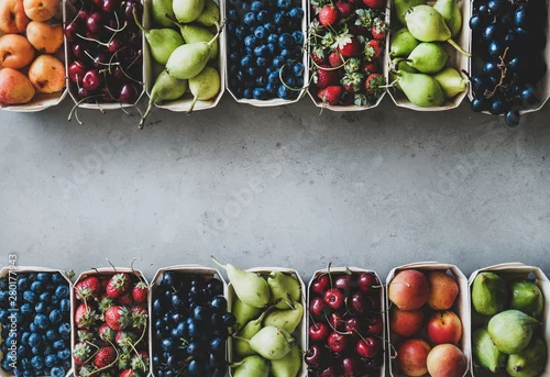 Obraz owoce: truskawki, wiśnie, winogrona, jagody, gruszki, morele, figi na szarym tle, widok z góry