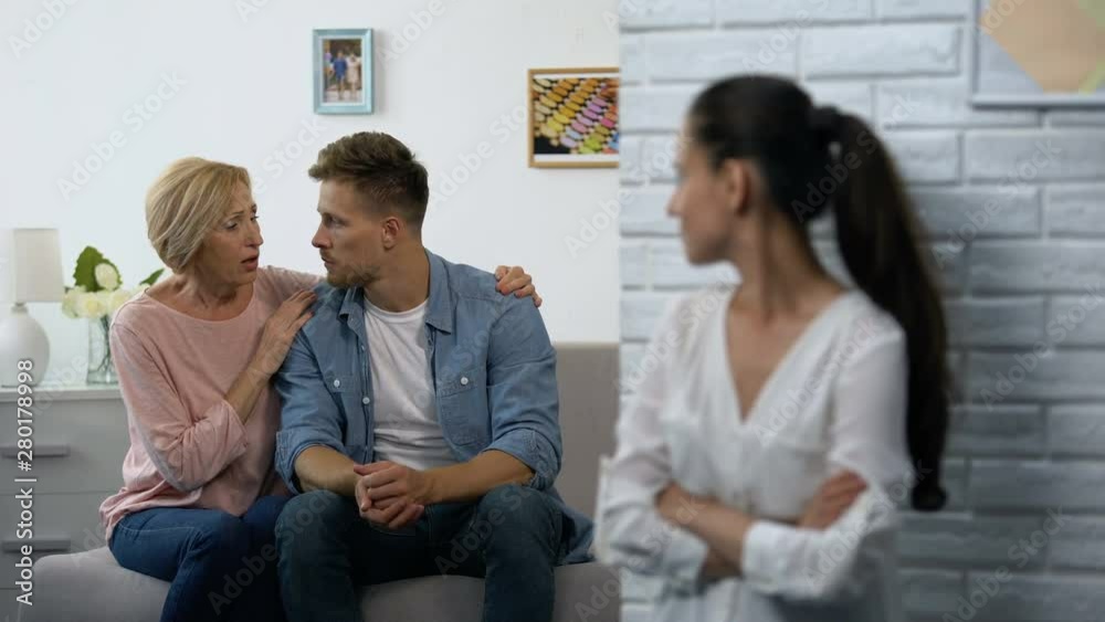 Offended woman secretly watching mother-in-law consoling husband after quarrel Offended woman secretly watching mother-in-law consoling husband after quarrel