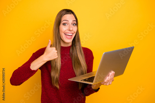Funny lady holding hands notebook raising thumb up approving good quality wear pullover isolated yellow background