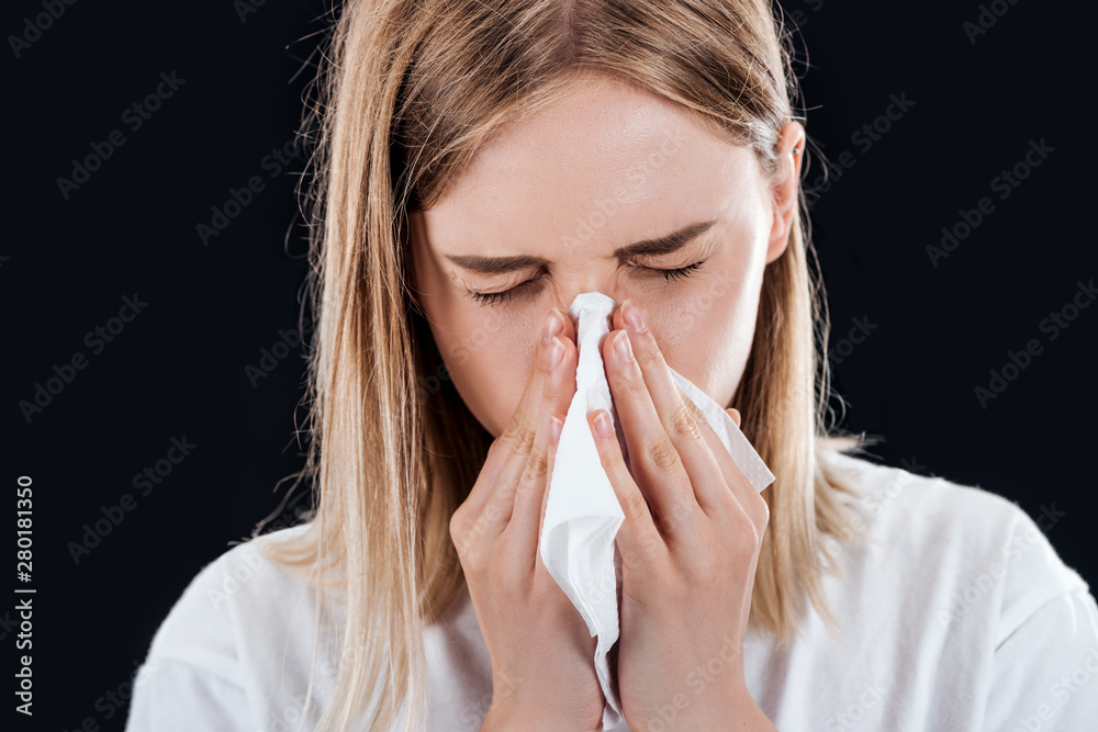 woman blowing her nose in napkin isolated on black woman blowing her nose in napkin isolated on black