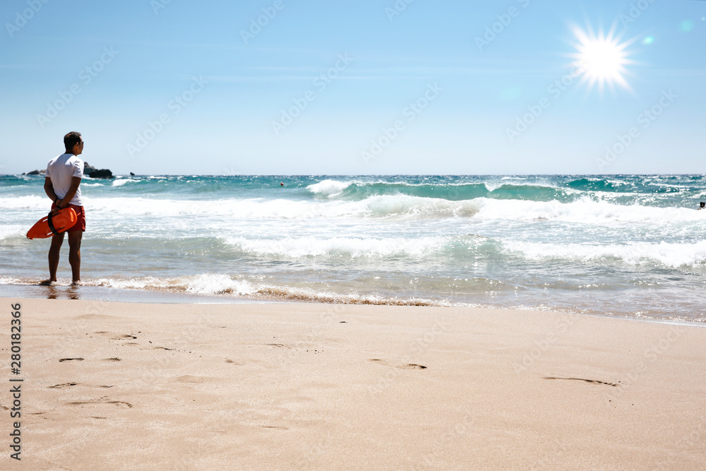 A lifeguard boy on the beach in a summer sunny day A lifeguard boy on the beach in a summer sunny day