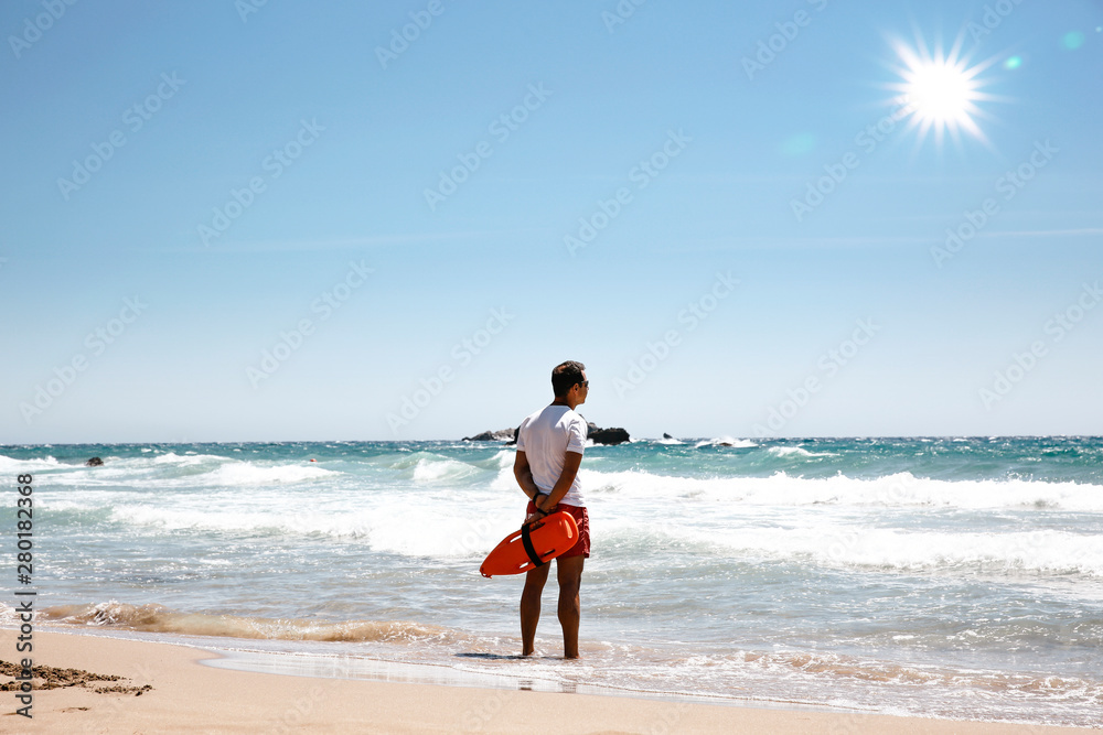 A lifeguard boy on the beach in a summer sunny day A lifeguard boy on the beach in a summer sunny day