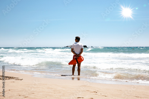 A lifeguard boy on the beach in a summer sunny day