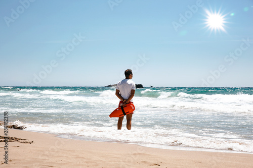 Fototapeta Naklejka Na Ścianę i Meble -  A lifeguard boy on the beach in a summer sunny day